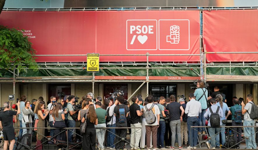 Journalists gather outside the headquarters of Spain's ruling Socialist Party as police search the building in Madrid, Wednesday, May 27, 2026. (AP Photo/Bernat Armangue)