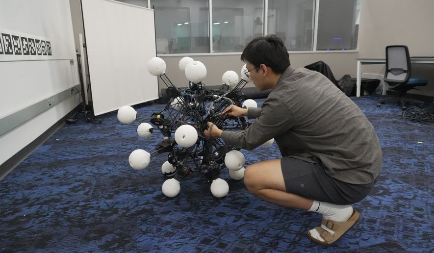 Jiaxun Liu, a Ph.D. student, works on a robot named Argus at Duke University's General Robotics Lab in Durham, N.C., Tuesday, May 26, 2026. (AP Photo/Allen G. Breed)