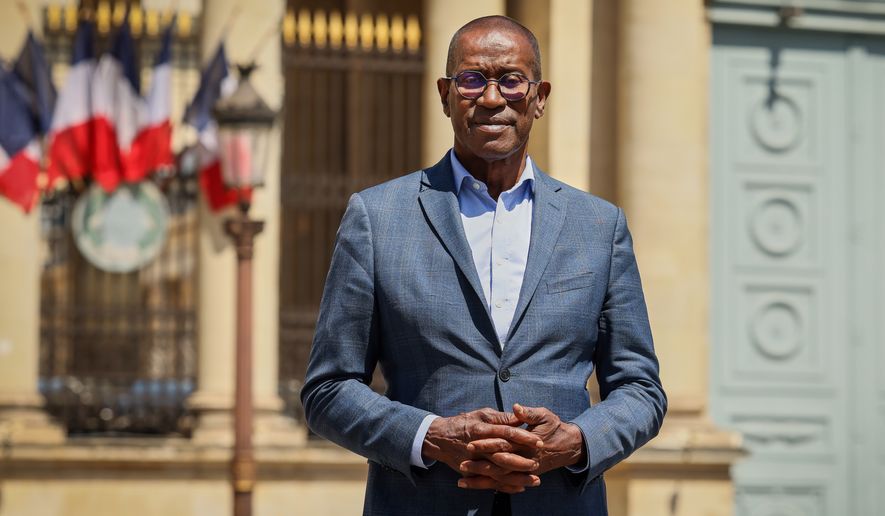French lawmaker Max Mathiasin of the French Caribbean island Guadeloupe, poses at the entrance of the National Assembly in Paris, Wednesday, May 27, 2026, before lawmakers examine a bill to formally repeal the Code Noir, or Black Code, the 17th-century royal edict that governed slavery in French colonies and treated enslaved people as property. (AP Photo/Thomas Padilla)