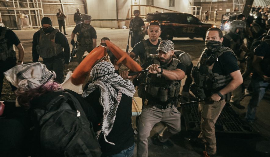 Protesters clash with ICE agents outside the Delaney Hall detention center while demonstrating near the entrance gates, Wednesday, May 27, 2026, in Newark, N.J. Inside the facility, detainees carried out a labor and hunger strike for days over alleged living conditions. (AP Photo/Andres Kudacki)