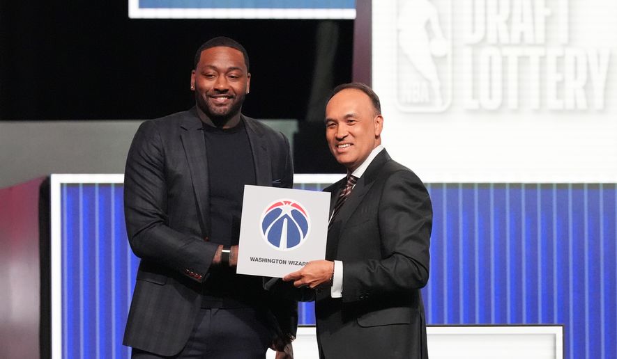Washington Wizards' John Wall, left, and NBA Deputy Commissioner Mark Tatum, pose for photos after Tatum announced that the Wizards had won the first pick in the NBA basketball draft lottery in Chicago, Sunday, May 10, 2026. (AP Photo/Nam Y. Huh)