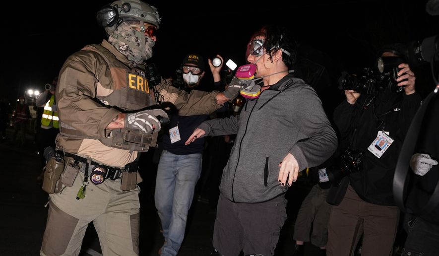 A federal immigration officer pulls the respirator mask from a protester outside Delaney Hall detention center Thursday, May 28, 2026, in Newark, N.J. (AP Photo/Angelina Katsanis)