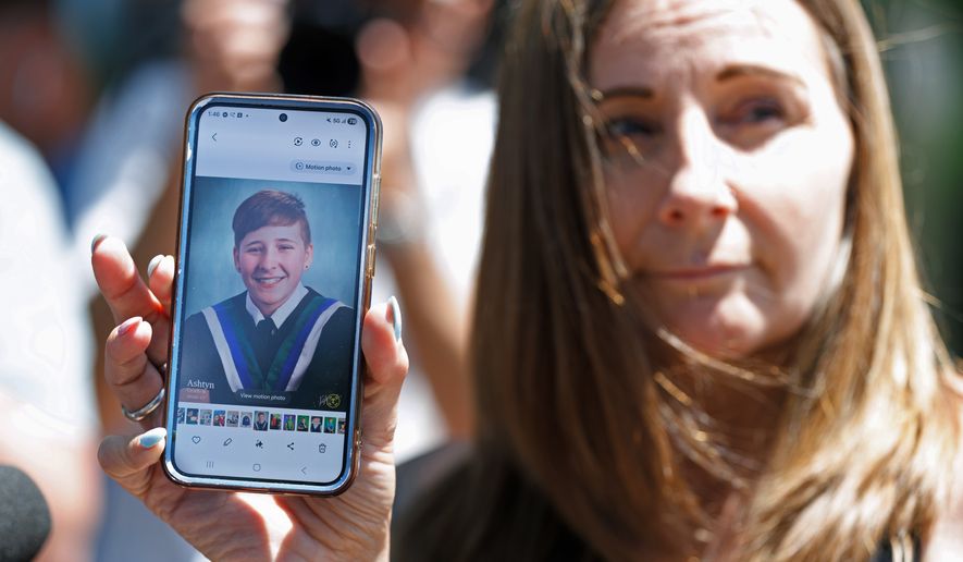 Kim Prosser holds a photo of her son Ashtyn outside the Ontario Court of Justice, Friday, May 29, 2026, in Newmarket, Ontario, after Kenneth Law pleaded guilty to 14 counts of counseling or aiding suicide, including the death of Prosser's son. (Christopher Drost/The Canadian Press via AP)