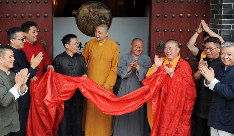 Shi Yongxin, third from right in yellow and red robes, abbot of the Shaolin Temple, attends the opening ceremony of an urban zen center named Shaolin Chan Hall in Xi'an in northwest China's Shaanxi province on Sunday June 28, 2015. (Chinatopix via AP, file)