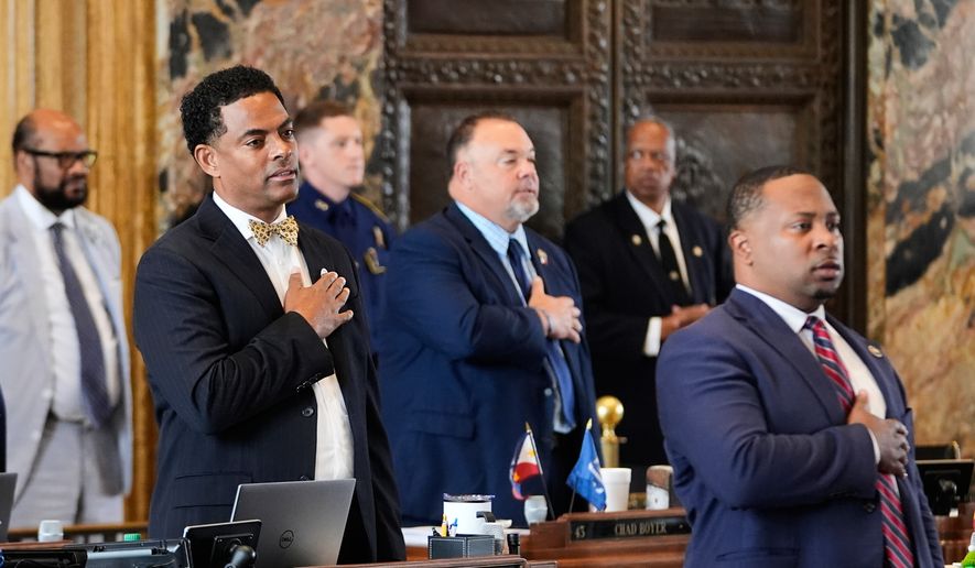 Louisiana Reps. Adrian Fisher, D-Dist 16, left, Chad Michael Boyer, R-Dist 46, and C. Travis Johnson, D-Dist 21, right, recite the pledge of allegiance prior to a house vote on a redistricting plan to eliminate a majority-Black congressional district in response to a U.S. Supreme Court ruling, in Baton Rouge, La., Thursday, May 21, 2026. (AP Photo/Gerald Herbert)