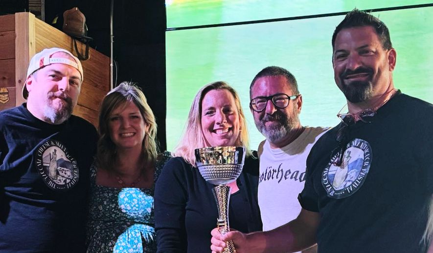 This photo provided by Kole Musgrove shows John Forsberg, far right, holding a trivia championship trophy and poses for a photo with other members of his team at Ashtown Brewing Company in Longview, Wash, on July 1, 2025. (Kole Musgrove via AP)