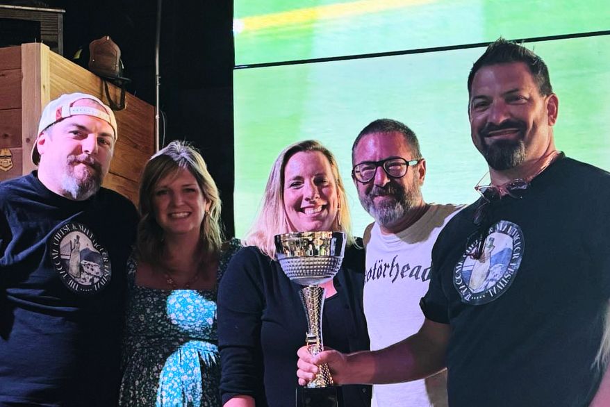 This photo provided by Kole Musgrove shows John Forsberg, far right, holding a trivia championship trophy and poses for a photo with other members of his team at Ashtown Brewing Company in Longview, Wash, on July 1, 2025. (Kole Musgrove via AP)