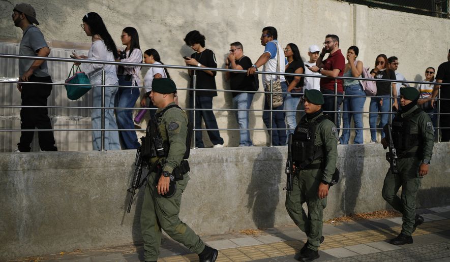 Soldiers patrol as voters arrive at a polling station during the presidential election in Barranquilla, Colombia, Sunday, May 31, 2026. (AP Photo/Ivan Valencia)
