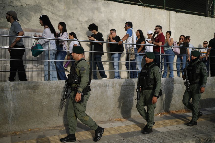 Soldiers patrol as voters arrive at a polling station during the presidential election in Barranquilla, Colombia, Sunday, May 31, 2026. (AP Photo/Ivan Valencia)