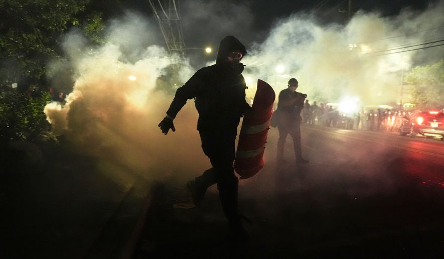 Anti-ICE protesters disperse during clashes with law enforcement officers outside the Delaney Hall detention center on Saturday, May 30, 2026, in Newark, N.J. (AP Photo/Angelina Katsanis)