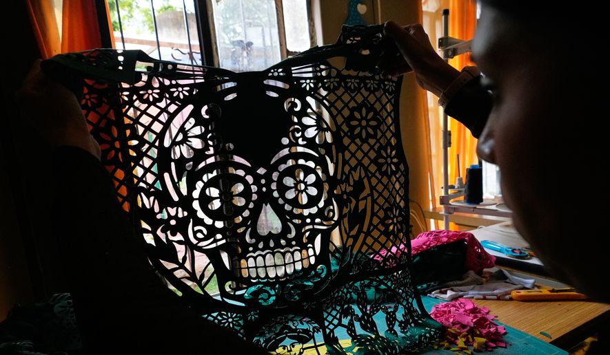 Cande Martinez prepares soccer jerseys, inspired by papel picado and traditional folk art, from the brand Mexclart, in Cuautitlán Izcalli, Mexico, Monday, May 25, 2026. (AP Photo/Marco Ugarte)
