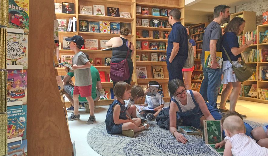 FILE - Customers appear in the children's area of the Books Are Magic bookstore, owned by author Emma Straub, in Brooklyn, New York, on April 29, 2017. (AP Photo/Beth J. Harpaz, File)