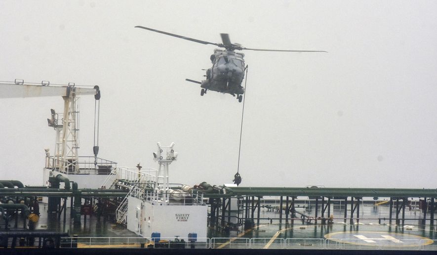 In this handout photo provided by the French Army, French soldiers use a rope from a NH90 helicopter intercepts an oil tanker that was traveling from Russia under international sanctions, on the Atlantic Sea, Sunday, May 31, 2026. (French Army via AP)
