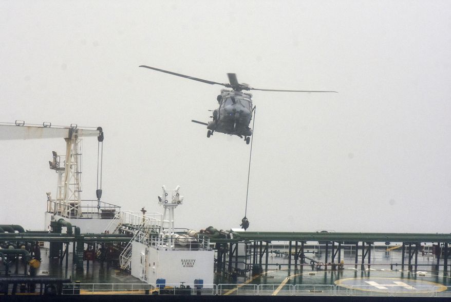 In this handout photo provided by the French Army, French soldiers use a rope from a NH90 helicopter intercepts an oil tanker that was traveling from Russia under international sanctions, on the Atlantic Sea, Sunday, May 31, 2026. (French Army via AP)
