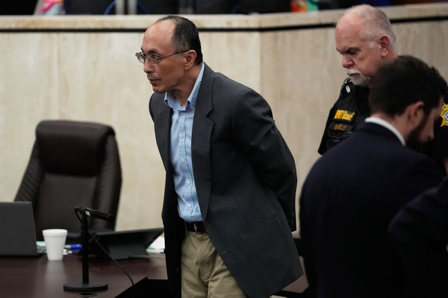 Chikei Rick Chow, left, accused in the 2023 fatal shooting of a Black 14-year-old, is escorted in the courtroom during his murder trial, Friday, May 29, 2026, in Columbia, S.C. (AP Photo/Erik Verduzco)