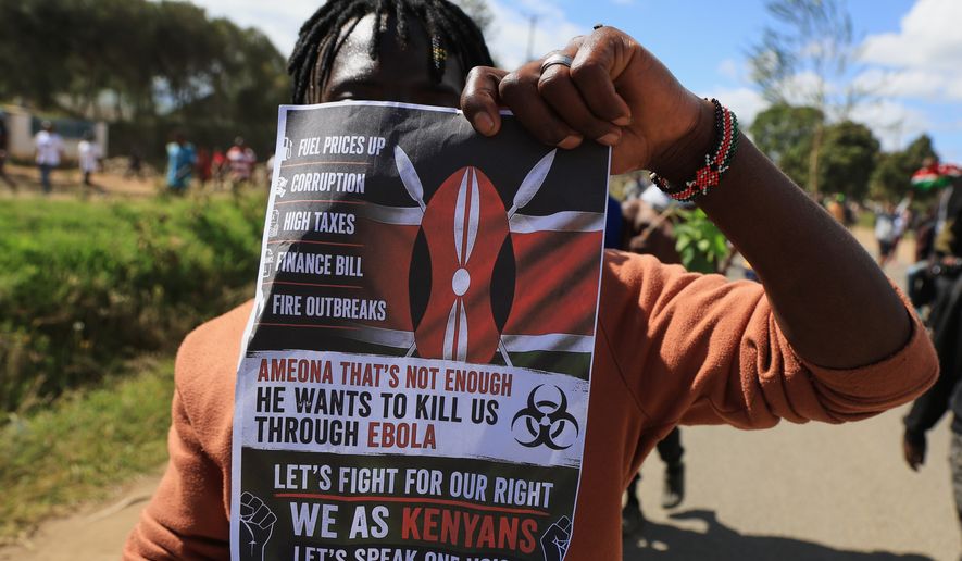 A protester holds up a placard during a demonstration against a proposed Ebola quarantine center to be established by the United States at Laikipia Air Base in Nanyuki, Kenya, Monday, June 1, 2026. (AP Photo/Andrew Kasuku)