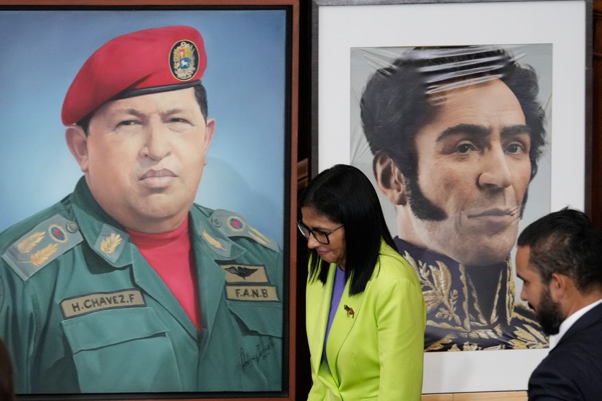 Venezuela's acting President Delcy Rodriguez walks past an image of former President Hugo Chavez, left, and Independence hero Simon Bolivar at the National Assembly in Caracas, Venezuela, Jan. 15, 2026. (AP Photo/Ariana Cubillos, File)