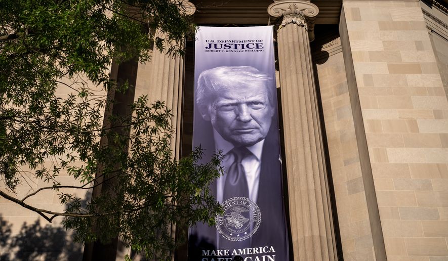A giant portrait of President Donald Trump looks down from the Justice Department in Washington, Tuesday, June 2, 2026. The Justice Department said it would comply with a court order pausing the implementation of a $1.776 billion settlement fund designed to compensate President Donald Trump's political allies after GOP senators revolted. (AP Photo/J. Scott Applewhite)