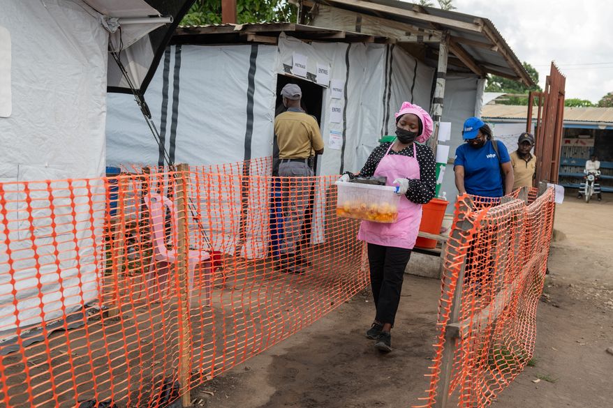 Kavugho Hortense, a cook, delivers meals to the medical staff and Ebola patients at the Evangelical Medical Center (CEM) in Bunia, Congo, Monday, June 1, 2026. (AP Photo/Moses Sawasawa)