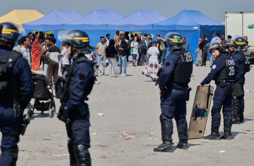 Police conduct a search operation at a makeshift camp of migrants who want to cross the English Channel to Britain near Dunkirk, northern France, Wednesday, May 27, 2026. (AP Photo/Jean-Francois Badias)