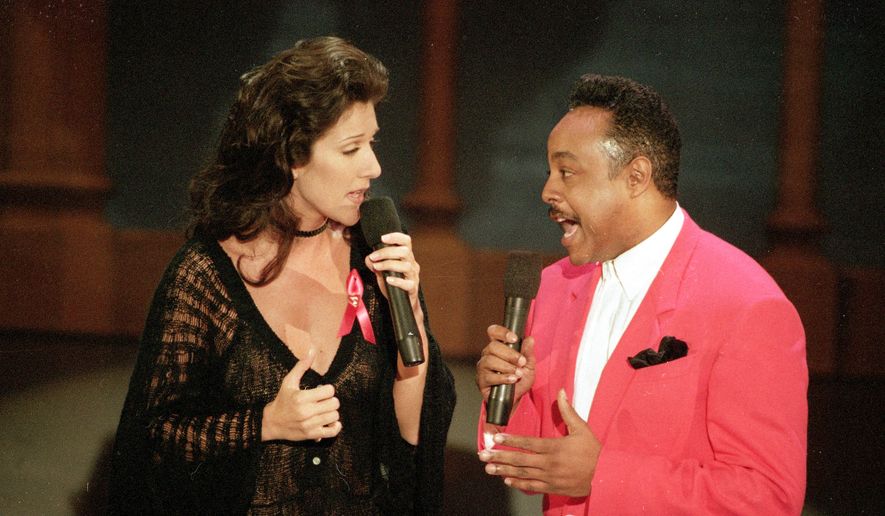 Celine Dion, left, and Peabo Bryson perform the song "Beauty and the Beast," which won them the Grammy for Best Pop Vocal Performance by a Group or Duo, at the 35th annual Grammy Awards in Los Angeles, Calif., Feb. 25, 1993. (AP Photo/Reed Saxon, File)