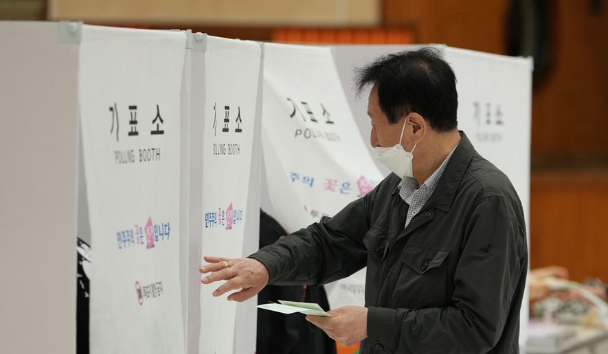 A voter arrives to cast his votes for the nationwide simultaneous local elections at a polling station in Seoul, South Korea, Wednesday, June 3, 2026. (AP Photo/Lee Jin-man)