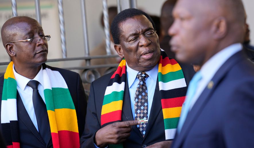 FILE - Zimbabwean President Emmerson Mnangagwa, center, stands next to his chief election agent and Justice Minister Ziyambi Ziyambi, left, outside the nomination court in Harare, Zimbabwe, June 21, 2023. (AP Photo/Tsvangirayi Mukwazhi, File)