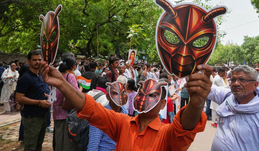 Supporters of the Cockroach Janta Party wear and display masks during a protest demonstration in New Delhi, India, Saturday, June 6, 2026. (AP Photo/Manish Swarup)