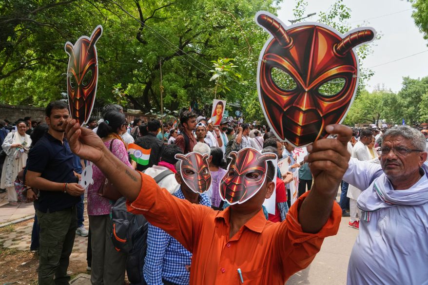 Supporters of the Cockroach Janta Party wear and display masks during a protest demonstration in New Delhi, India, Saturday, June 6, 2026. (AP Photo/Manish Swarup)