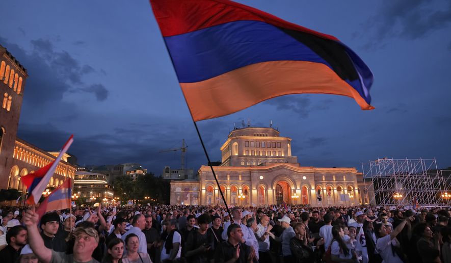 Supporters of Russian-Armenian tycoon Samvel Karapetyan, wave a Armenian national flag during a rally against incumbent Prime Minister Nikol Pashinyan at Republic Square in Yerevan, Armenia, Wednesday, June 3, 2026, as Karapetyan, who heads the Strong Armenia party, has faced criminal charges that he rejected as politically driven and campaigned from under house arrest. (AP Photo/Anthony Pizzoferrato)