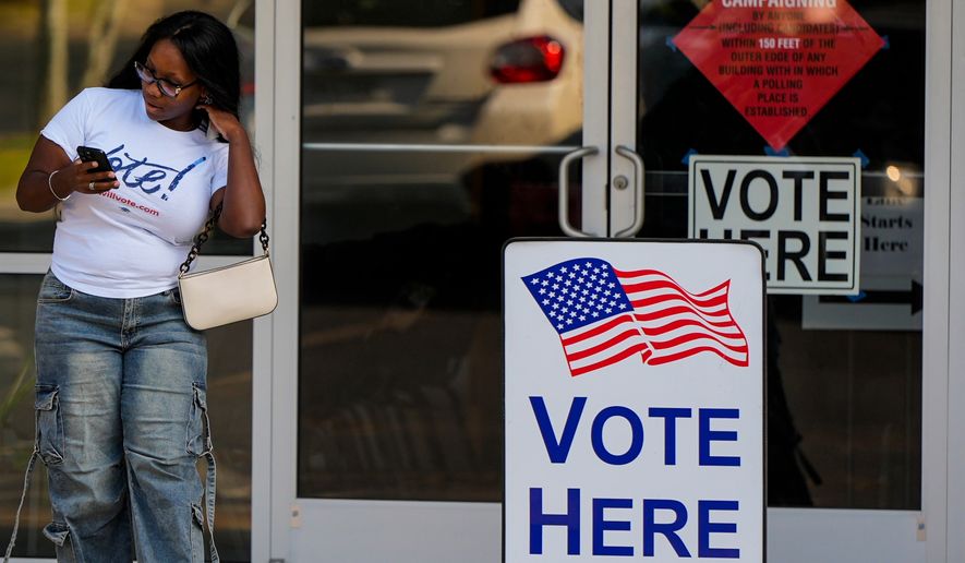 A woman leaves a voting center after voting, Tuesday, May 19, 2026, in Marietta, Ga. (AP Photo/Mike Stewart)