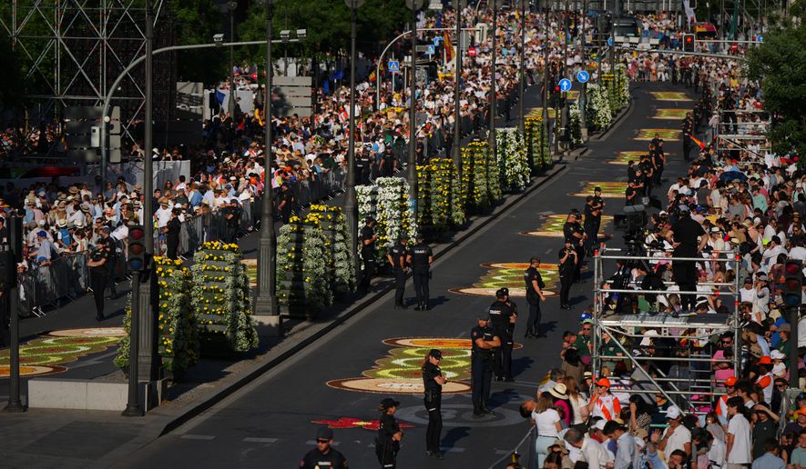 People wait for the arrival of Pope Leo XIV ahead of a Holy Mass and Corpus Christi procession at Plaza de Cibeles in Madrid, Spain, Sunday, June 7, 2026, on the second day of his seven-day apostolic visit to mainland Spain and the Canary Islands. (AP Photo/Manu Fernandez)