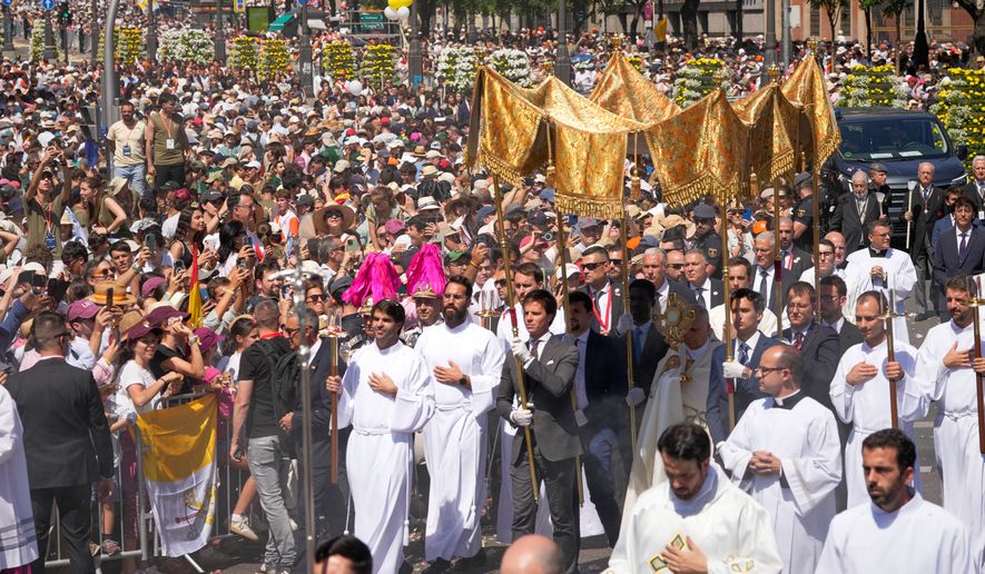 Pope Leo XIV takes part in a procession marking the Catholic feast of Corpus Christi at Plaza de Cibeles in Madrid, Spain, Sunday, June 7, 2026, on the second day of his seven-day apostolic visit to mainland Spain and the Canary Islands. (AP Photo/Bernat Armangue)