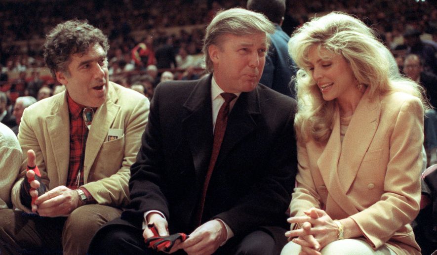 FILE - Actor Elliott Gould, left, joins Donald Trump, center, and Marla Maples at courtside during an NBA basketball game between the Phoenix Suns and the New York Knicks at Madison Square Garden, in New York, March 6, 1991. (AP Photo/Steve Freeman, File)