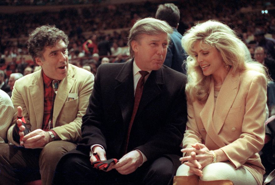 FILE - Actor Elliott Gould, left, joins Donald Trump, center, and Marla Maples at courtside during an NBA basketball game between the Phoenix Suns and the New York Knicks at Madison Square Garden, in New York, March 6, 1991. (AP Photo/Steve Freeman, File)