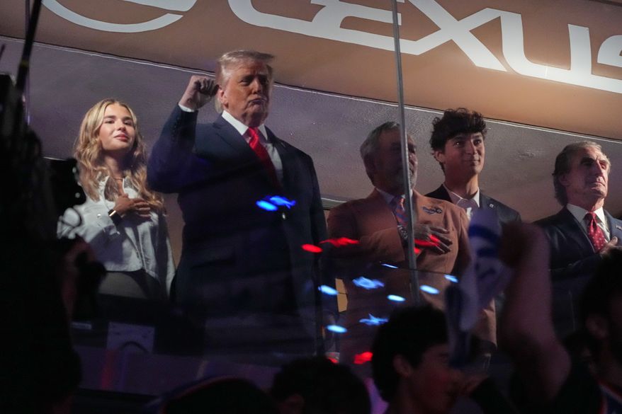 President Donald Trump gestures during the National Anthem as he attends an NBA Finals playoff basketball game between the New York Knicks and the San Antonio Spurs at Madison Square Garden in New York, Monday, June 8, 2026, with Kai Trump, left, Knicks owner James Dolan and Interior Secretary Doug Burgum, right. (AP Photo/Mark Schiefelbein)
