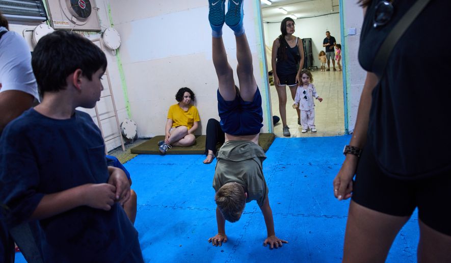 People take shelter as air raid sirens warning of incoming Iranian missiles in Ramat Gan, Israel, Monday, June 8, 2026. (AP Photo/Oded Balilty)