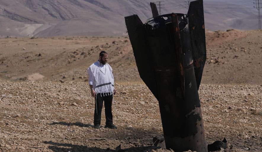 A man look at the wreckage of an Iranian missile that landed near the West Bank city of Jericho Monday, June 8, 2026. (AP Photo/Mahmoud Illean)