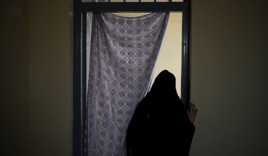 FILE - An Afghan woman walks out of a cell inside the women's section of the Pul-e-Charkhi prison in Kabul, Afghanistan, on Sept. 23, 2021. (AP Photo/Felipe Dana, File)