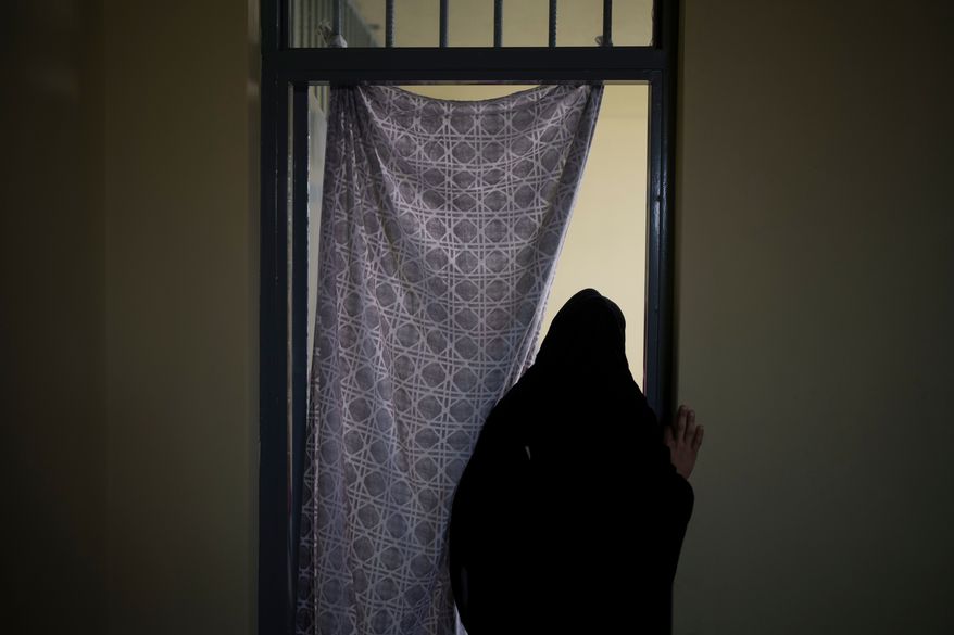 FILE - An Afghan woman walks out of a cell inside the women's section of the Pul-e-Charkhi prison in Kabul, Afghanistan, on Sept. 23, 2021. (AP Photo/Felipe Dana, File)