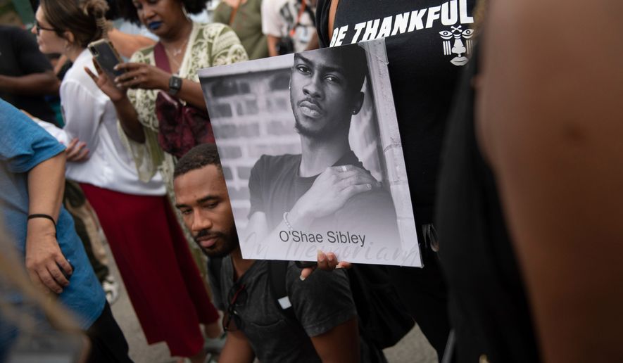 A person holds up a photo of O'Shae Sibley during a vigil at a gas station, Aug. 4, 2023, in the Brooklyn borough of New York. (AP Photo/Tracie Van Auken, File)