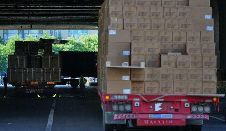Workers transfer goods from a truck at the Xiaomi logistic center, in Beijing, China on Friday, May 29, 2026. (AP Photo/Andy Wong)