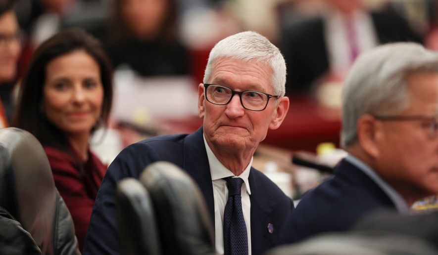 Apple CEO Tim Cook attends a meeting between Chinese Premier Li Qiang and U.S. business representatives, at the Great Hall of the People in Beijing, Thursday, May 14, 2026. (Go Nakamura/Pool Photo via AP)