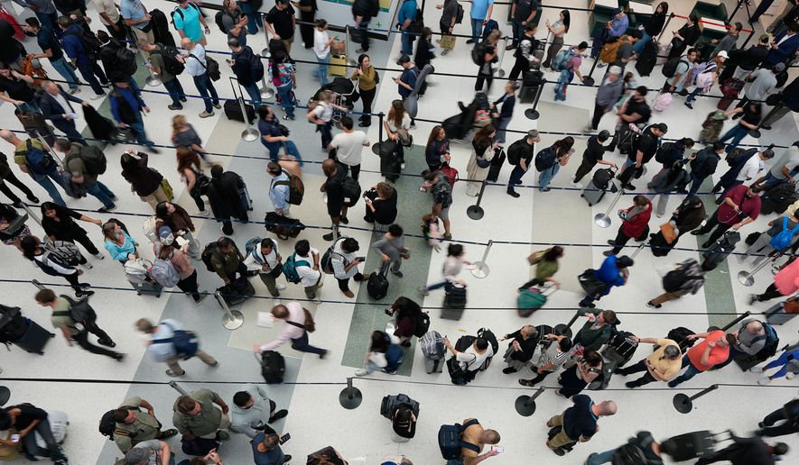 FILE - Travelers wait in long security checkpoint lines at George Bush Intercontinental Airport March 27, 2026, in Houston. (AP Photo/David J. Phillip, File)