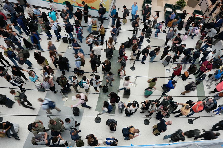 FILE - Travelers wait in long security checkpoint lines at George Bush Intercontinental Airport March 27, 2026, in Houston. (AP Photo/David J. Phillip, File)