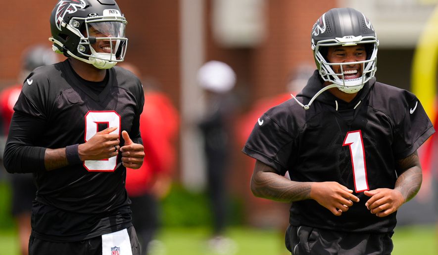 Atlanta Falcons quarterback's Michael Penix Jr. and Tua Tagovailoa (1) move during an NFL football practice, Wednesday, May 27, 2026, in Flowery Branch, Ga. (AP Photo/Mike Stewart)