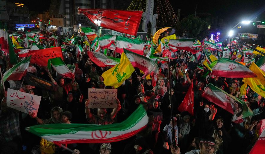 Pro-government Iranian demonstrators wave flags from Iran and Lebanon's Hezbollah in Tehran, Iran, Sunday, June 7, 2026. (AP Photo/Vahid Salemi)