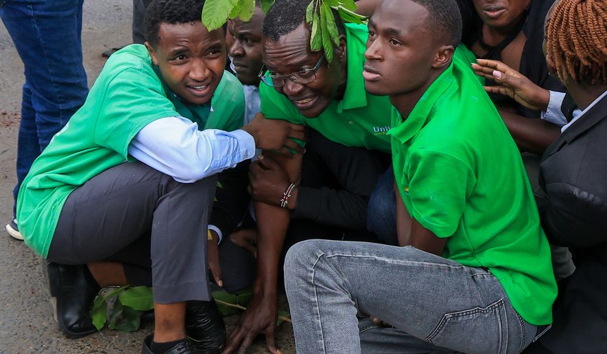 Kenya's former chief justice and presidential contender David Maraga, center, is shielded by protesters during a protest over plans affecting Nairobi National Park in Nairobi, Kenya, Monday, June 8, 2026. (AP Photo/Andrew Kasuku)