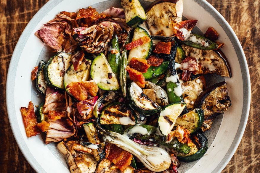 This image released by Voracious shows a recipe for grilled garden vegetables with bacon vinaigrette from the cookbook "Chasing the Gator" by Isaac Toups and Jennifer V. Cole. (Denny Culbert/Voracious via AP)
