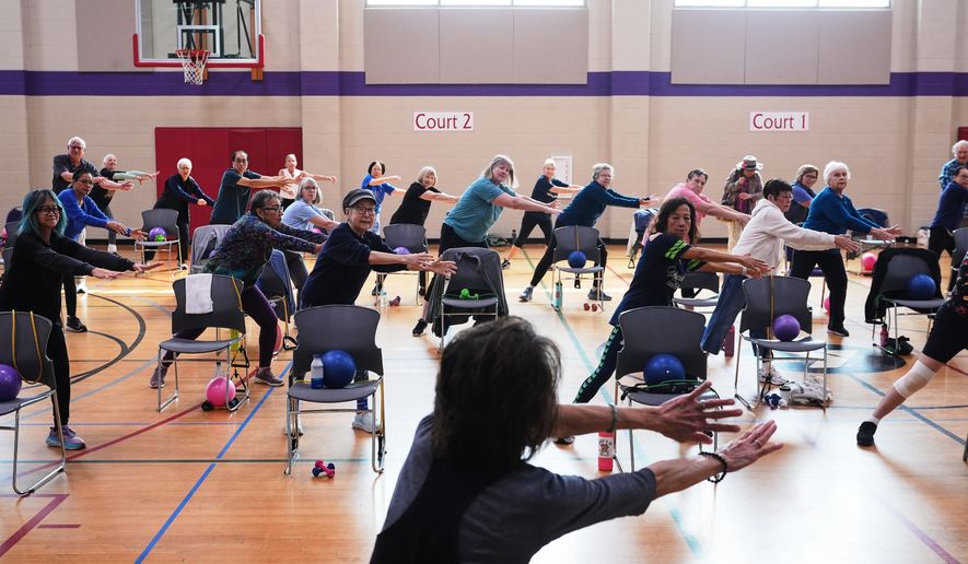 Instructor Bengie Santos, 72, at front, leads an exercise class for older adults at the Dale Turner Family YMCA, April 30, 2026, in Shoreline, Wash. (AP Photo/Lindsey Wasson)